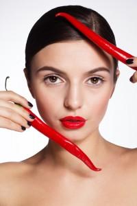 Woman holding cayenne peppers up to her face