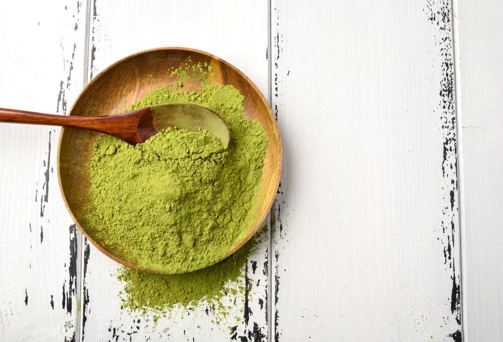 Matcha powder in a wooden bowl with spoon