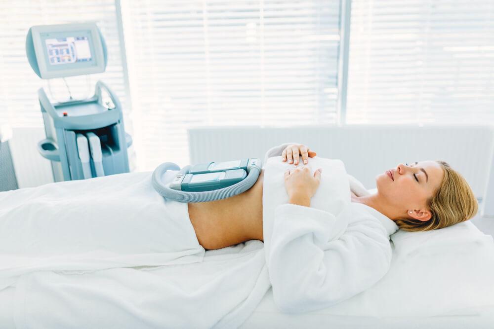 Woman undergoing body sculpting and fat reduction treatment