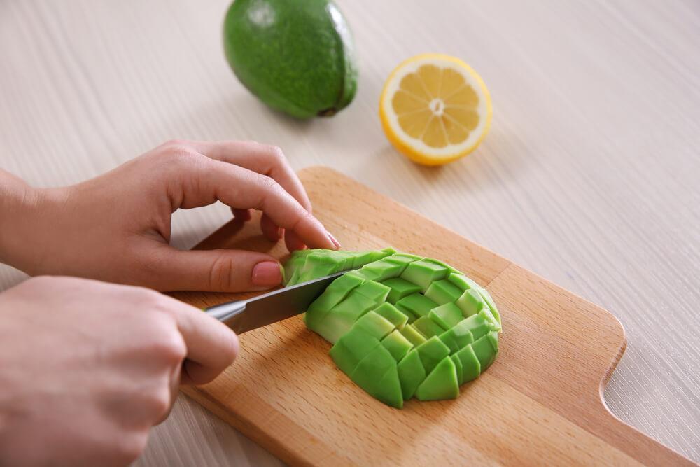 Hands slicing avocado