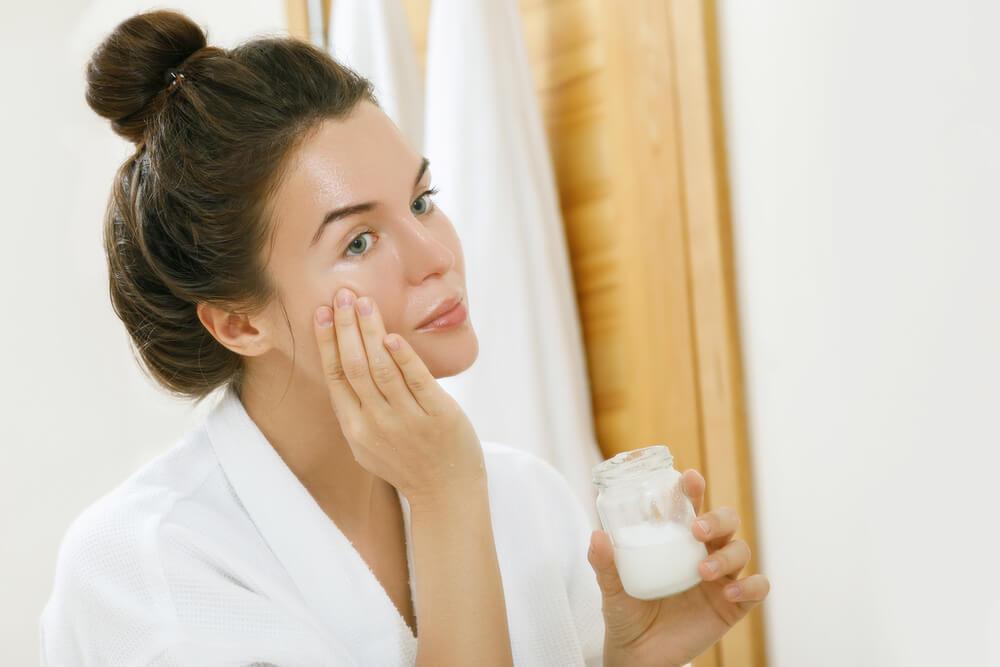 Woman applying oil to face