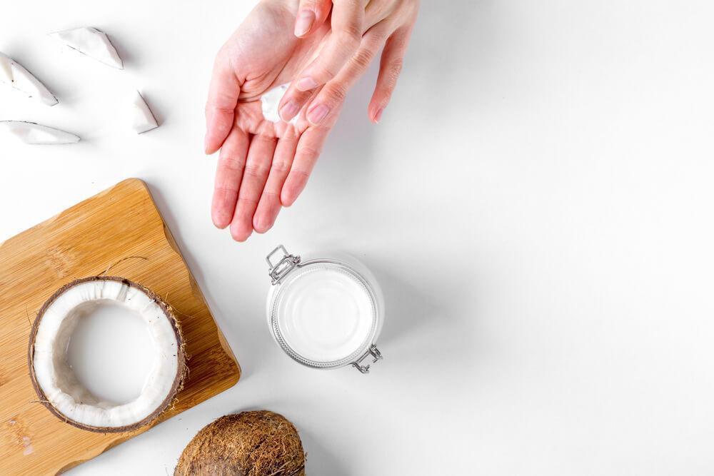 Woman using coconut oil on hands