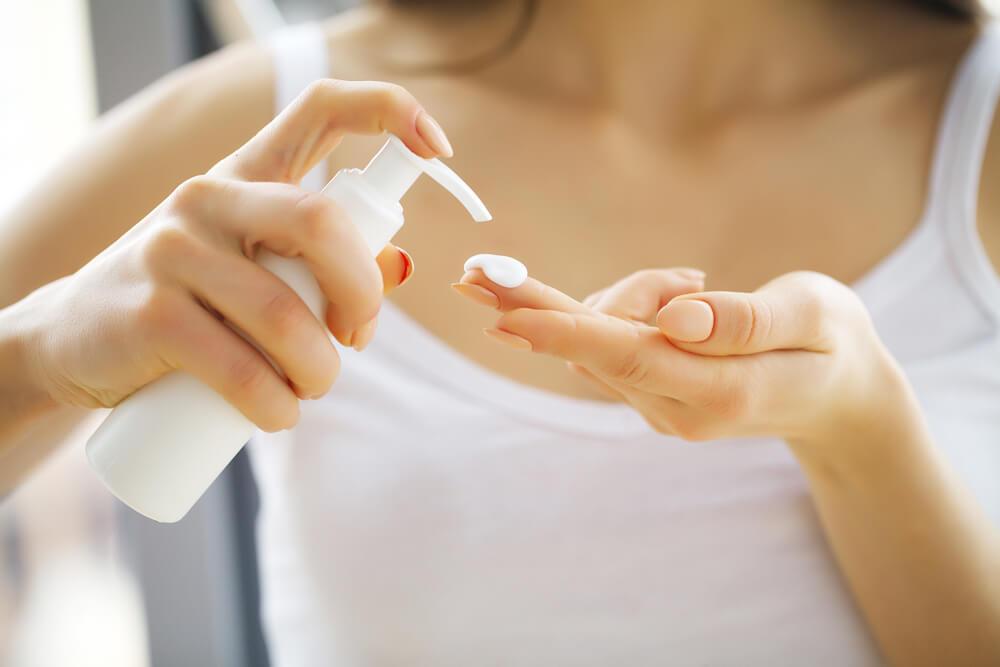 Woman applying lotion to hand