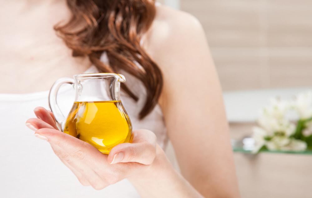 Hand holding olive oil jug