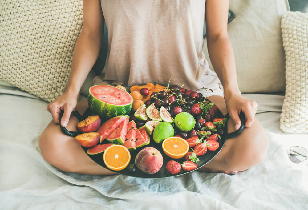 person holding platter of fruit