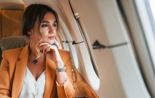 Woman in window seat wondering what flying will do to her skin